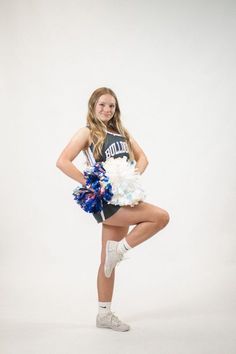 a young woman is posing with cheerleader pom poms