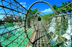 a man is walking across a rope bridge