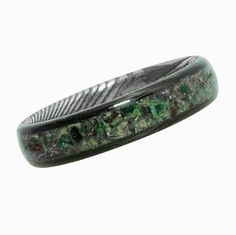 "This 5mm Jade Carbon Fiber Ring has a Stainless Damascus Steel core and is inlaid with Meteorite Shavings and Dinosaur Fossil! The ancient Triceratops dinosaur fossil, is from a piece of its frill shield that was preserved underground for millions of years until it was recently discovered in North Dakota. The fossil has been split into small pieces and suspended in protective natural resin. The dinosaur bone is mixed with even older meteorite, the extraterrestrial pieces found in the Muonionalu Dinosaur Ring, Dinosaur Bone Ring, Carbon Fiber Ring, Dinosaur Fossil, Damascus Ring, Carbon Fiber Rings, Damascus Steel Ring, Bone Ring, Dark Jewelry