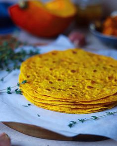 a stack of corn tortillas sitting on top of a white napkin next to a knife