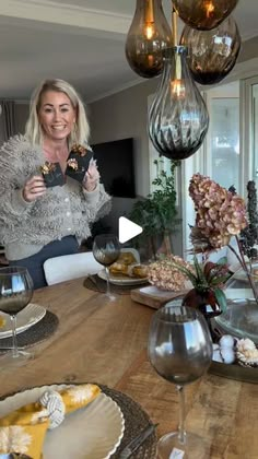 a woman standing in front of a table filled with food and wine glasses on it