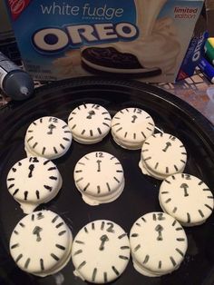 white fudge oreo cookies are arranged in the shape of clocks on a pan