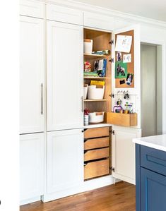 a kitchen with white cabinets and wooden drawers on the doors is shown in this image