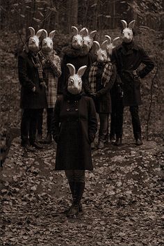 a woman standing in front of a group of people wearing bunny ears