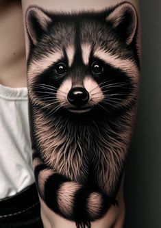 a woman's arm with a raccoon tattoo design on the left forearm