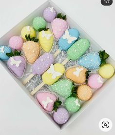 a box filled with lots of colorfully decorated strawberries and marshmallows