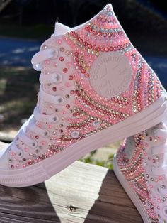 "There's nothing like having your own \"Custom Bling'd out Converse!\" These converse are fully strassed in high quality crystals. These are the perfect custom converse for weddings. Colors shown in picture: white high top shoe with clear, dark pink, pink ab and pink pearls colored stones. Each stone is hand placed on each shoe given you that custom bling to perfection. They can be customized in any color and can be designed in Infants, Toddlers and Big Kids sizes. For Children Sizes, please cli Diy Glitter Shoes Sneakers, Blinged Converse Shoes, Pink And Green Bling Converse, Decorate Shoes, Colorful Gym Shoes, Bedazzled Converse, Rhinestone Converse, Upcycle Shoes, Converse Design