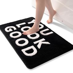 the feet of a person standing on a black door mat that says get your book back