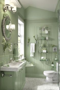 a bathroom with green walls and white fixtures