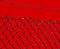 the fence is covered in water droplets on it's sides, and red background