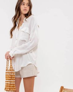 This long sleeve button down features a boyfriend fit for a comfy, laid back vibe. Crafted with breathable fabric, it is the perfect layering essential for warm summer days and breezy nights. You've got options! Pair this versatile summer staple with shorts and sneakers for a casual brunch, or throw it on over your favorite bikini for a beach to bar look. Soft, lightweight fabric with the prettiest crinkle texture. Oversized silhouette for a relaxed and effortless look. Single chest pocket. Butt Summer Long Sleeve Tops With Pockets, Casual Beach Tops With Button Cuffs, Effortless Summer Tops With Pockets, Summer Tops With Button Cuffs For Day Out, Oversized Summer Tops With Buttoned Pockets, Casual Tops With Buttoned Pockets For Day Out, Oversized Tops With Buttoned Pockets For Summer, Trendy Summer Tops With Buttoned Pockets, Versatile Summer Tops With Button Cuffs