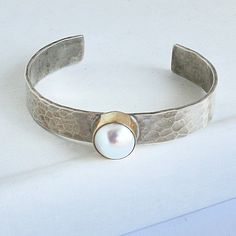 Please allow 3-5 weeks for this to be custom made and ship Sterling silver cuff with 14kt gold bezel and 1 Mother of Pearl Designed by Richard Schmidt Modern Hammered Cuff Jewelry, Richard Schmidt, Pearl Cuff, Hammered Sterling Silver, Pearl Design, Sterling Silver Cuff, Schmidt, Silver Cuff, 14kt Gold