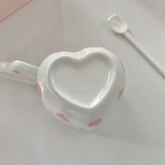 a toothbrush holder with a heart design on it and a spoon next to it