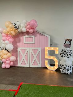 a decorated barn with balloons and decorations for a farm birthday or baby's first birthday