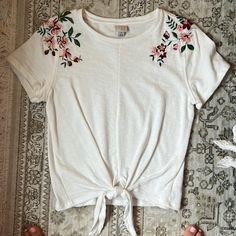 Cotton T-Shirt Emboirdered Shoulders, Spills Over To Back Tie Bottom Thick Material Nwot Size S Target Cotton T-shirt With Embroidery For Spring, Casual Embroidered T-shirt For Summer, White Crew Neck Top With Floral Embroidery, White Embroidered T-shirt For Summer, Casual White Top With Floral Embroidery, White Floral Embroidered T-shirt For Spring, White Short Sleeve T-shirt With Floral Embroidery, White Floral Embroidery Short Sleeve T-shirt, White Floral Embroidered T-shirt