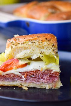 a close up of a sandwich on a plate with lemons and bread in the background