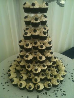 a tower of cupcakes with black and white frosting on top is displayed