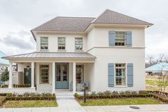 a white two story house with blue shutters