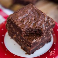 two pieces of chocolate brownie on a red and white plate