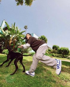 a man is playing with his dog in the grass