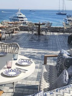 an outdoor dining area overlooking the ocean and boats