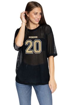 a woman wearing a black shirt with the number 20 on it and gold lettering,