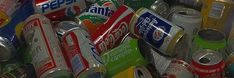 a pile of soda cans stacked on top of each other in different colors and flavors