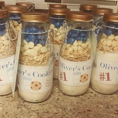 four jars filled with different types of cookies in them on top of a kitchen counter