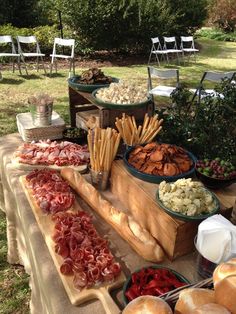 an assortment of food is displayed on a picnic table