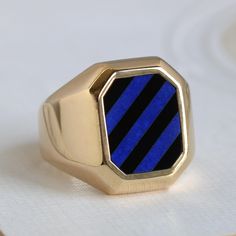 A chunky mid-century signet-style ring, crafted in solid 18k yellow gold featuring a striped face of lapis lazuli in a luminous shade of blue alternating with inky black onyx. It's a bold but elegant design, and although originally meant for a man's hand this would make a striking modern statement for a woman. Measuring approximately 3/4" north to south with a smooth taper through slightly angled shoulders to 6.72 mm at the center back of the band. Currently size 9 and resizable about two full s Timeless Blue Signet Ring With Polished Finish, Timeless Blue Signet Ring For Formal Occasions, Locket Necklace Vintage, Locket Bracelet, Diamond Stacking Rings, Blue Ring, Custom Gift Boxes, Vintage Diamond Rings, Original Jewelry