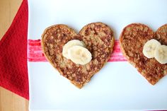 two heart shaped pancakes with banana slices on them