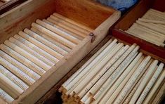 an open box filled with lots of wooden dows on top of a table next to other boxes