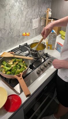 a person cooking food on top of a stove with a wooden spatula in front of it