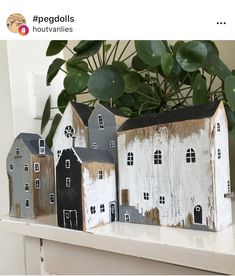 three wooden houses sitting on top of a mantle