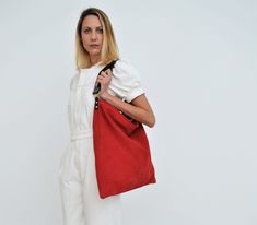 Akathi bag in red. A beautiful large hobo bag which is ideal for every day use. Not just a shoulder bag, a statetment hobo bag which can elevate any outfit. It's loose minimalistic look makes it modern and unique.  Handmade in our studio from lux italian suede red leather and a premium calf leather for the strap in  black. Big rectangular metal loops in gold or silver are used to connect the strap with the bag and a metal swivel clasp is added in the interior for handling keys or wallet. A leather pocket made from suede leather is included at the interior. The interior is unlined and has the same look with the exterior. Dimensions: Height, 46 cm (18,11 inches) Length, 44 cm (17,32 inches) Strap, 50 cm from one side to the other (19,7 inches) We ship all of our items worldwide. Colors may v Cheap Red Pouch Hobo Bag, Everyday Red Soft Leather Hobo Bag, Red Hobo Bag With Leather Handles For Everyday Use, Red Hobo Bag With Leather Handles For Errands, Red Hobo Bag With Leather Handles, Red Hobo Bag With Double Leather Handles, Red Hobo Shoulder Bag With Leather Handles, Red Double Handle Hobo Bag With Leather Handles, Red Hobo Bag With Removable Pouch