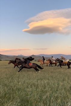 several people are riding horses in the field