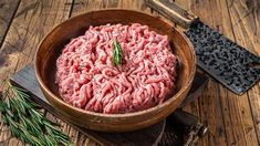 a wooden bowl filled with raw ground meat