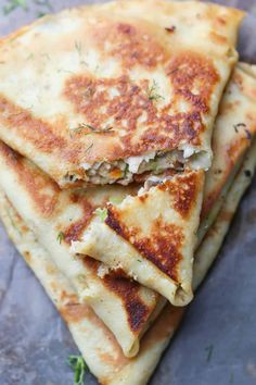 four pieces of flat bread stacked on top of each other with herbs and seasoning