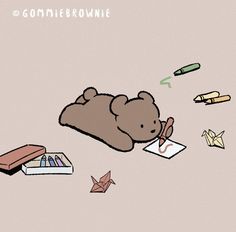 a brown teddy bear laying on top of a pile of paper