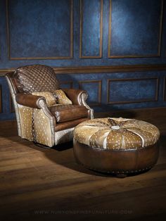 a chair and ottoman in front of a blue wall with wood flooring on it