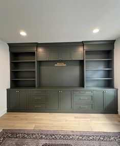 an empty room with built in cabinets and rug