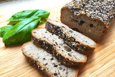 slices of bread with seeds and spinach on a cutting board