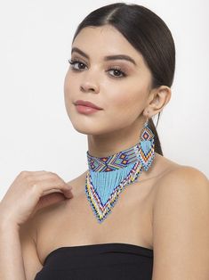 a woman wearing a black top and blue beaded choker necklace with matching earrings