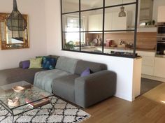 a living room filled with furniture and a large mirror on the wall above it's windows