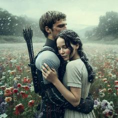 a man and woman hugging in the middle of a field with wildflowers on it