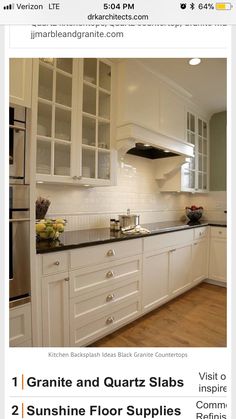 a kitchen with white cabinets and black counter tops