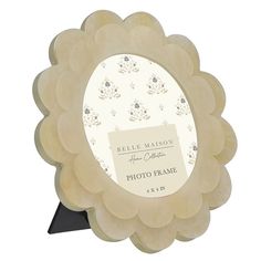 a photo frame with a flower design on the front and bottom, is shown in beige