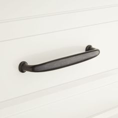 a black handle on a white cabinet door