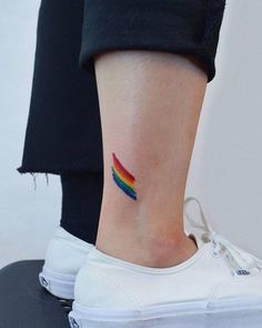 a small rainbow tattoo on the ankle