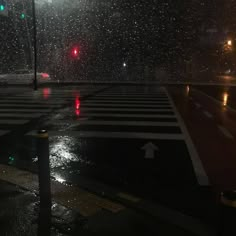 an empty crosswalk in the rain at night